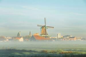 Popular tourist spot Zaanse Schans is near Amsterdam in the west of the Netherlands. Historical, realistic windmills during sunrise. Holland's landmark photo