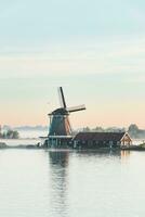 Popular tourist spot Zaanse Schans is near Amsterdam in the west of the Netherlands. Historical, realistic windmills during sunrise. Holland's landmark photo