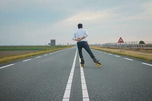 hermoso joven atleta patines en holandés carreteras a mejorar resistencia y aptitud física. un joven hombre trenes estabilidad y disfrutando el Fresco aire. deporte estilo de vida foto