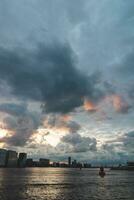 tormenta nubes durante puesta de sol viaje mediante el ciudad de Amsterdam y dar un dramático atmósfera. holandés estilo de vida y moderno ciudad paisaje foto