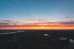 Aerial view of nightlife in the modern city of Rotterdam in the Netherlands. Red glow from the setting sun in the background photo