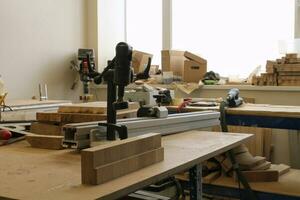 Craft carpentry workshop with variety of wooden pieces and planks, hand tools and wooden work bench in the foreground. Joinery with workbench and lots of wood. Carpenters table with furniture details photo