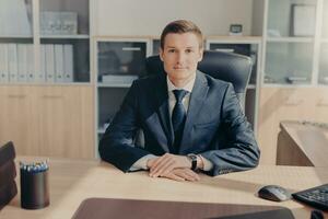 Confident executive at desk in a well-lit office photo