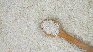 White long rice in a wooden spoon. Banner. Top view. Close-up. Selective focus. photo