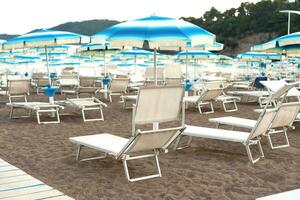 Empty sandy beach with umbrellas and sunbeds. Beach season. Empty beaches during a pandemic. Selective focus. photo