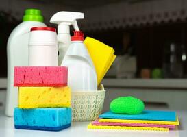 Spring-cleaning of the house. Various detergents and cleaning products on the table in the kitchen. Close-up. Selective focus. photo