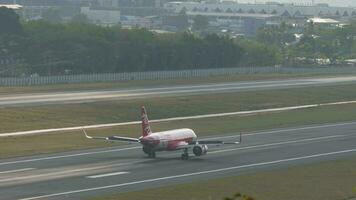 PHUKET, THAILAND - FEBRUARY 19, 2023. Passenger plane Airbus A320 of AirAsia braking after landing at Phuket airport, sid eview. Spoilers up. Low cost airline in Asia video