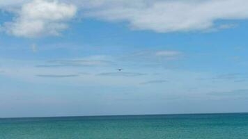 avión acercándose aterrizaje terminado el mar. avión terminado el playa, azul cielo antecedentes video