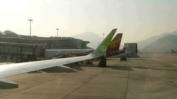 HONG KONG - NOVEMBER 07, 2019. Chek Lap Kok International Airport, Hong Kong. View of the wing of an S7 Airlines aircraft. Hong Kong Airlines plane at the telescopic bridge video