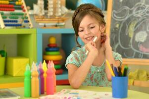 Portrait of cute girl drawing picture at home photo