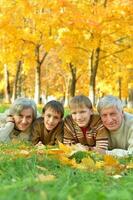 linda familia acostado en un otoño parque foto