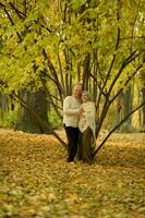 mayor Pareja danza en el parque en otoño. foto