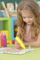 Portrait of cute girl drawing picture at home photo