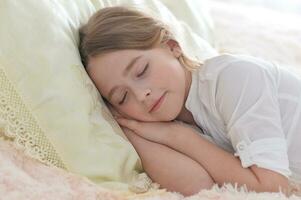 adorable linda pequeño niña dormido en cama foto