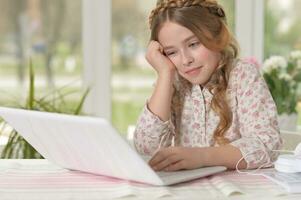 Cute and happy little girl children using laptop computer photo