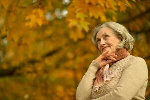 Senior woman walking in the park in autumn. photo