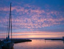 Sailing ship in the harbor of lake Vaettern at sunset. Lighthouse in the background photo