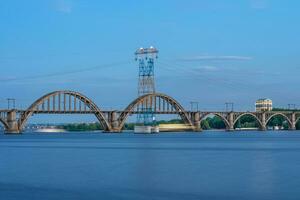 pintoresco paisaje de el ucranio dnipro ciudad con antiguo arco ferrocarril merefo-kherson puente a través de el dniepr río en Ucrania. foto