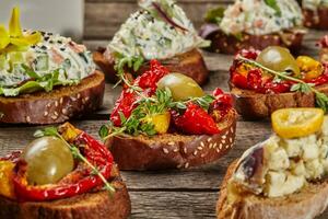 Canapes on toasted baguette slices with various toppings photo