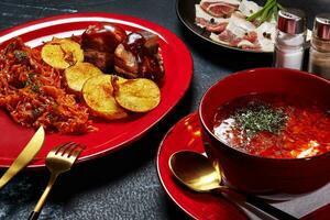 Set lunch of red borscht, potatoes, stewed cabbage, fried bacon and salted pork belly photo