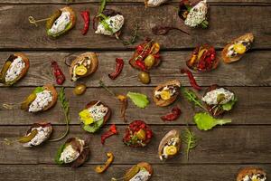 Crostini on toasted bread with various toppings on wooden background photo