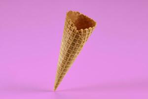 Empty, tasty wafer cone for ice cream against pink background. Concept of food, treats. Mockup, template for your advertising and design. Close up photo