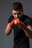 Sporty man with hands wraps standing in orthodox fighting stance photo