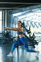 activo niña haciendo extensión ejercicio antes de formación a gimnasio foto