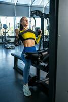 Girl performing neutral grip lat pull-down on gym machine photo