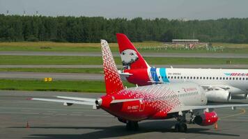 SAINT PETERSBURG, RUSSIA - JULY 26, 2022. Sukhoi Superjet 100, RA-89092 of Yamal Airlines and Sukhoi Superjet 100, RA-89127 of Rossiya on the apron at the terminal at Pulkovo airport video