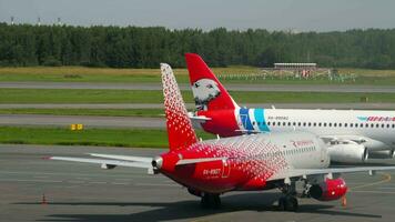 Santo petersburgo, Rusia - julio 26, 2022. sukhoi Super Jet 100, ra-89092 de yamal aerolíneas y sukhoi Super Jet 100, ra-89127 de rosiya en el delantal a el terminal a pulkovo aeropuerto video