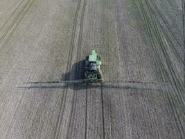 Tractor with hinged system of spraying pesticides. Fertilizing w photo