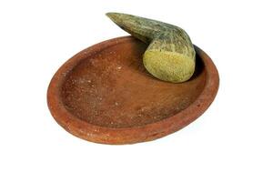 Traditional mortar and pestle made of clay and wood on a white background photo