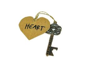 Old key with heart tag isolated on white background photo