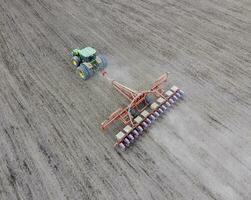 Sowing of corn. Tractor with a seeder on the field. Using a seed photo