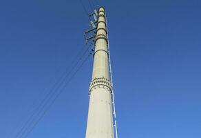 Supports high-voltage power lines against the blue sky photo