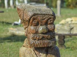 The face of a bearded old man carved out of logs photo