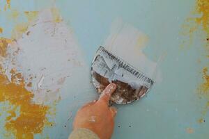 Closeup of a man aligning a wall with spatula and trowel. photo