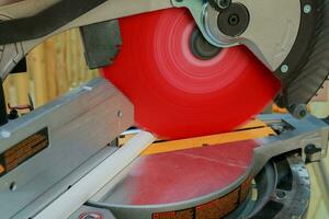 man cutting wood on electric saw photo