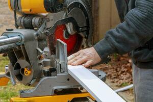 Side view of mid adult manual worker cutting wood photo