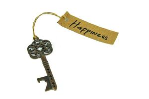 Old decorative key and handwritten tag Happiness tied with straw rope on white background photo