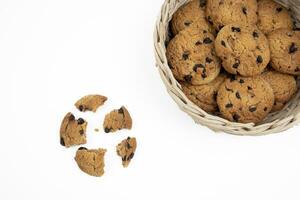 Chocolate chip cookies in a bamboo basket and crushed chocolate chip cookies on a white background photo