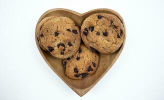 Chocolate chip cookies on a heart shaped plate on a white background photo