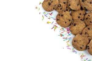 Chocolate chip cookies and colorful sprinkles on a white background photo