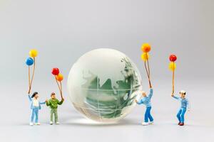 un alegre familia con un globo rodeando un cristal globo y el concepto de mundo tierra día foto