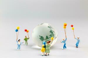 A joyful family with a balloon encircling a crystal globe  and the conncept of World Earth Day photo