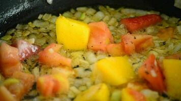 Koken in een heet pan met mango, tomaat, aardbei en ui video