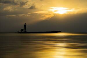 Silhouettes of fisherman at the lake with sunset, Thailand. photo