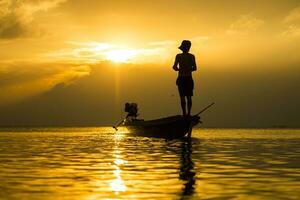 Silhouettes of fisherman at the lake with sunset, Thailand. photo