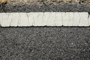 Asphalt with old white road line. photo